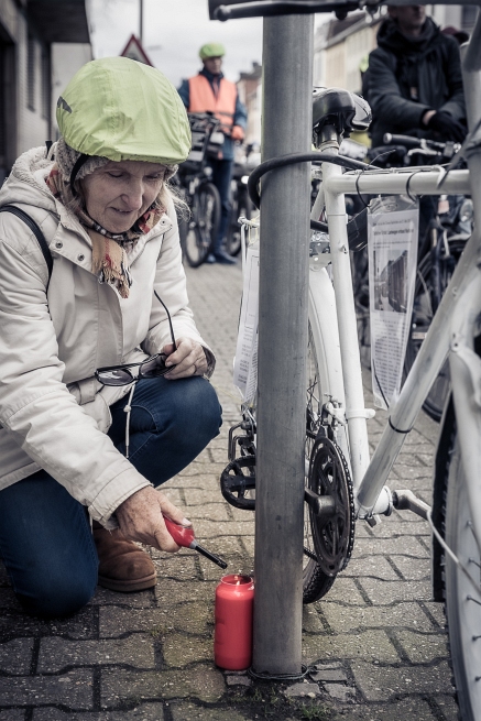 Eine Frau zündet ein Grablicht an, zum Gedenken an den jungen Radfahrer
